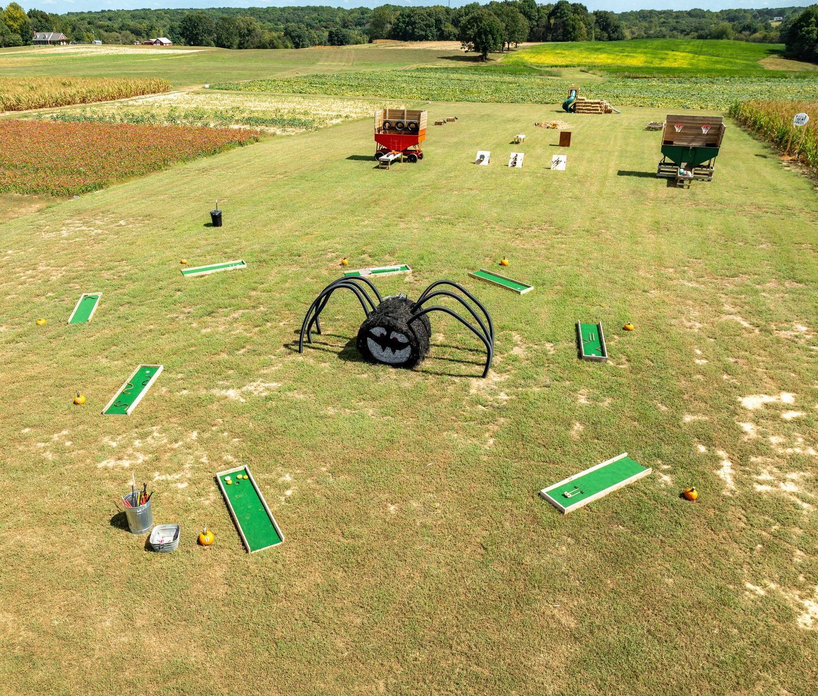 An aerial view of a golf course with a giant spider in the middle.