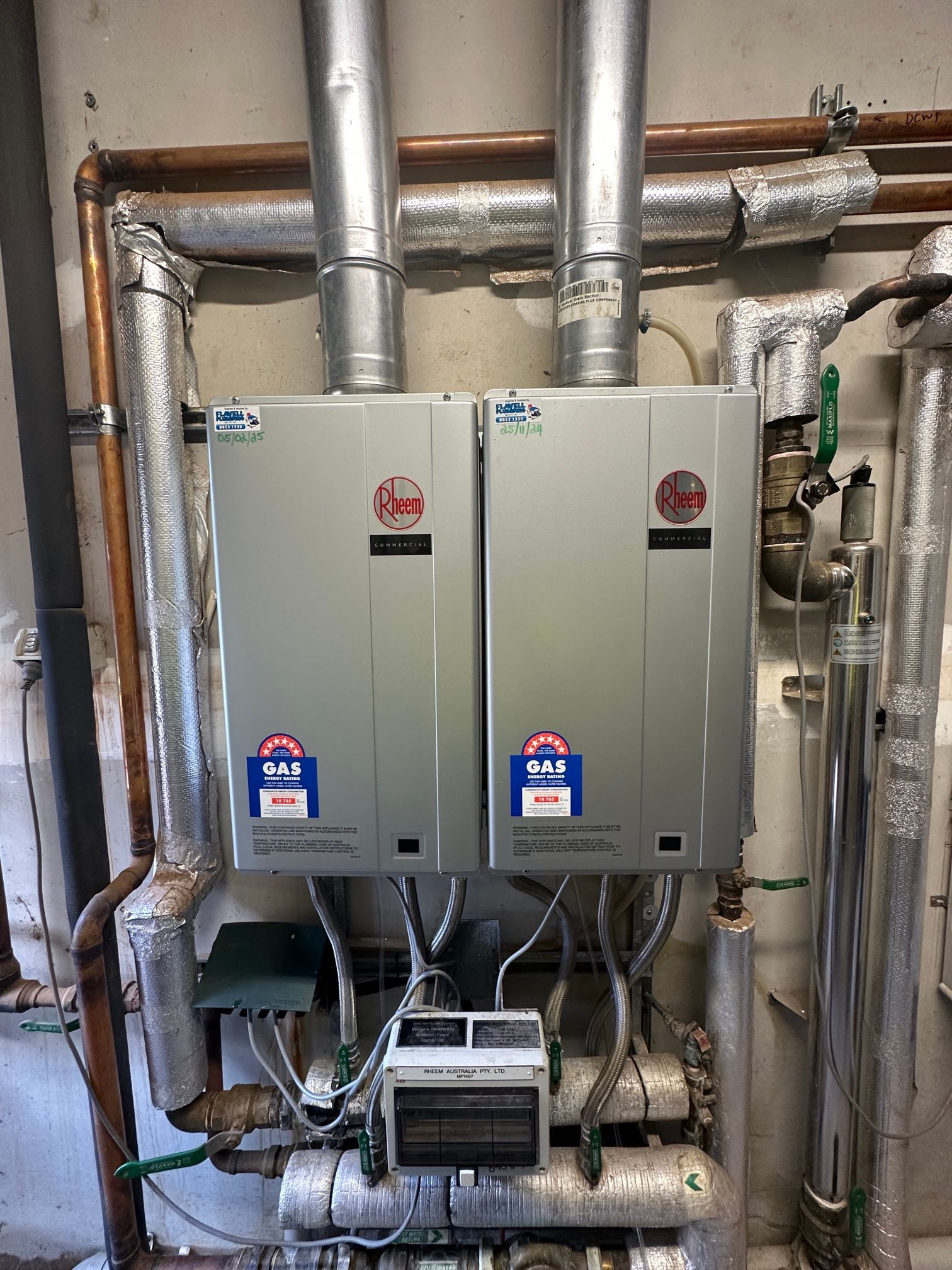 A White Water Heater Is Sitting Next To A White Boiler In A Room — Flavell Plumbing (NT) Pty Ltd In Ciccone, NT