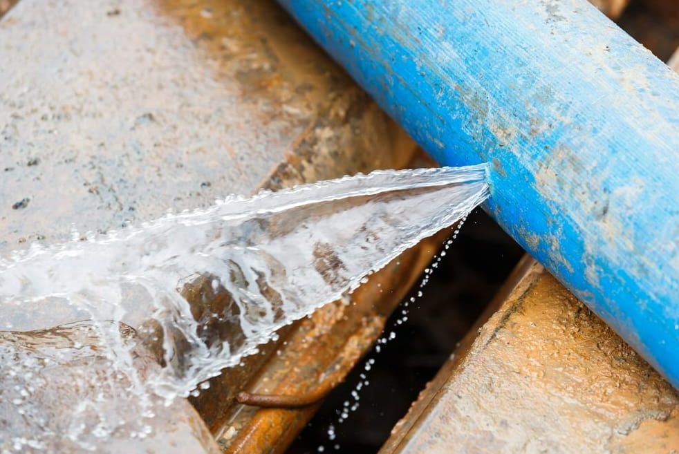 A Blue Pipe Is Leaking Water Into A Hole In The Ground — Flavell Plumbing (NT) Pty Ltd In Ciccone, NT