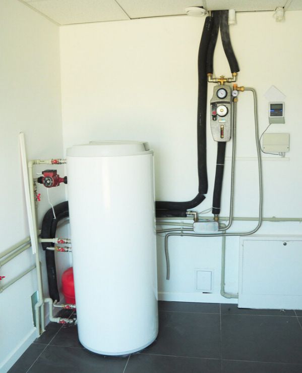 A White Water Heater Is Sitting In The Middle Of A Room — Flavell Plumbing (NT) Pty Ltd In Ciccone, NT