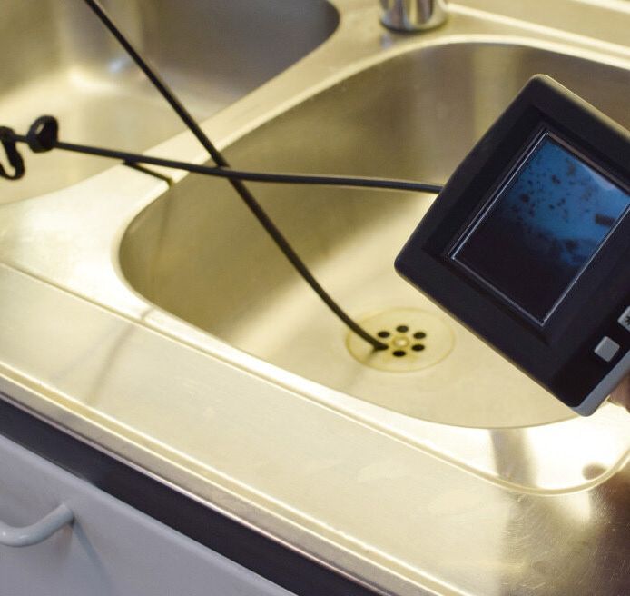 A Person Is Holding A Camera In Front Of A Sink — Flavell Plumbing (NT) Pty Ltd In Ciccone, NT