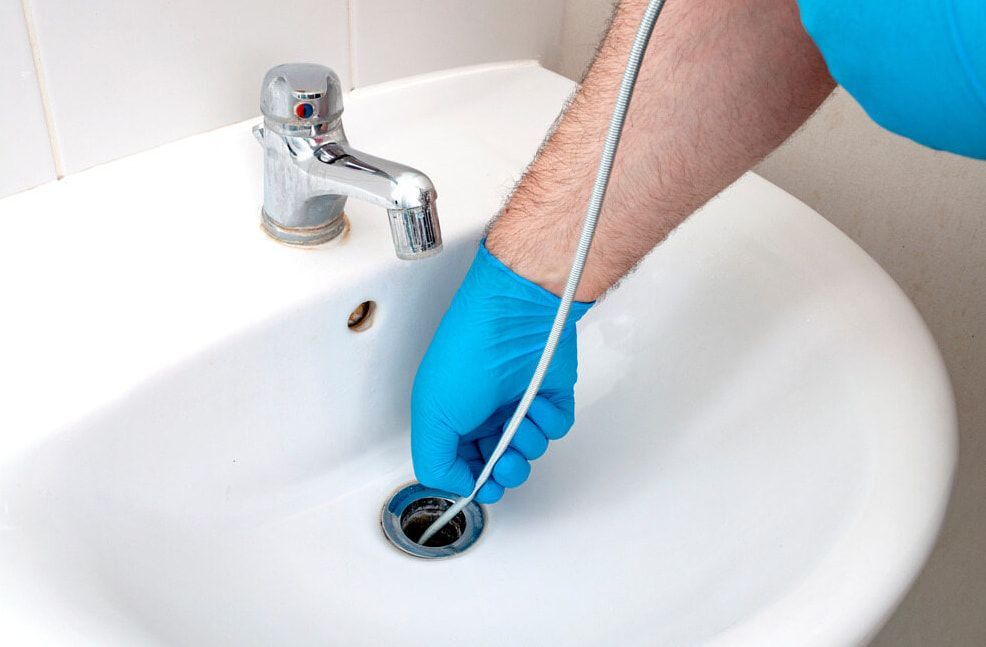 A Person Is Cleaning A Sink With A Hose — Flavell Plumbing (NT) Pty Ltd In Ciccone, NT