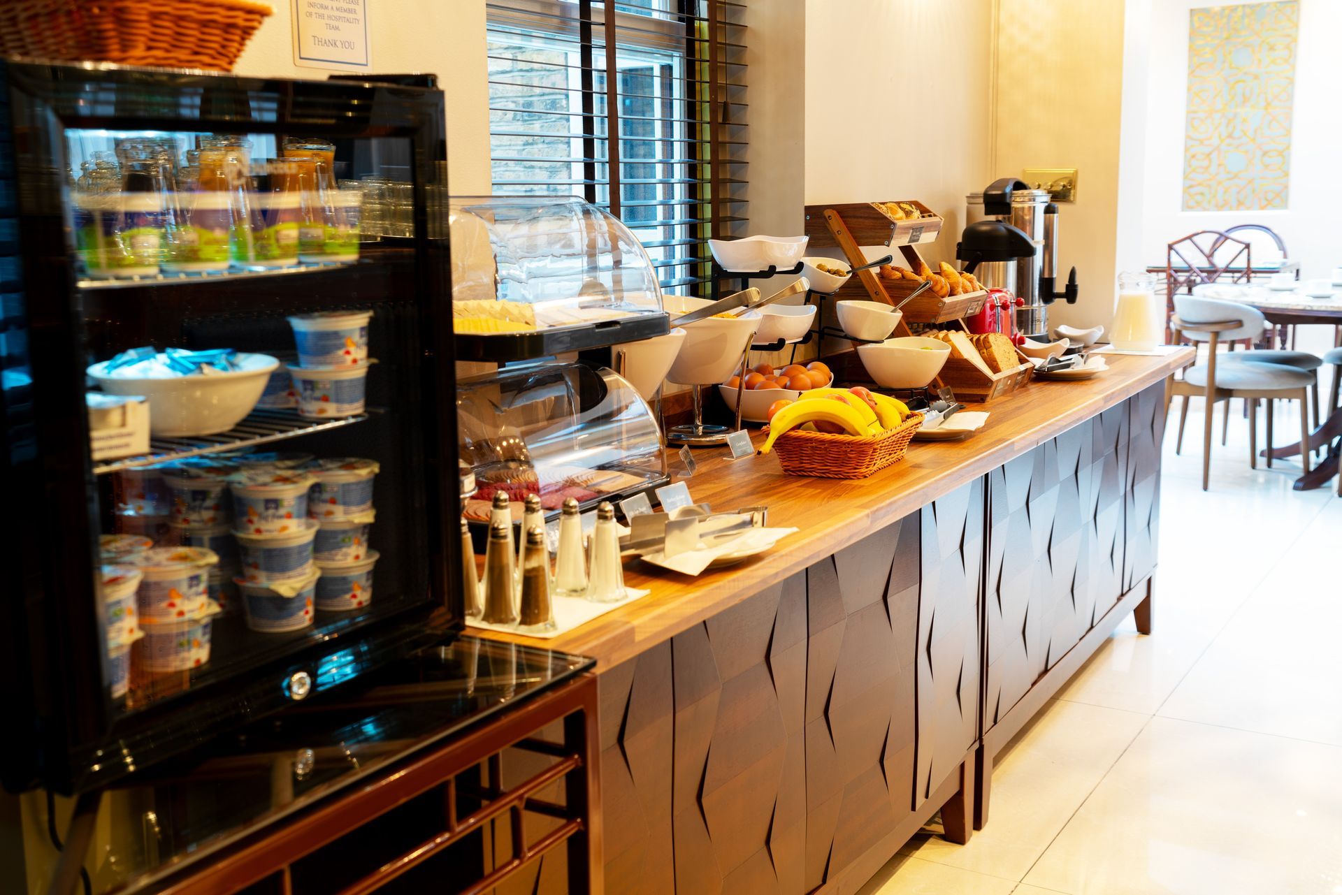 Breakfast room with round table buffet, chandeliers, chairs, TV, and open doorway to a counter.