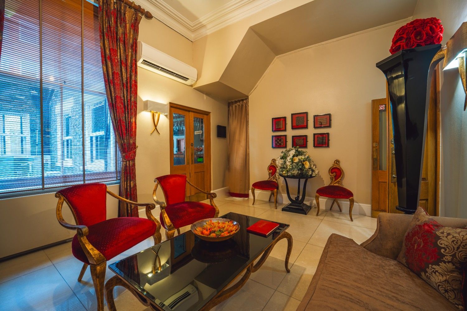 Elegant living room with red chairs, ornate furniture, and a grandfather clock.