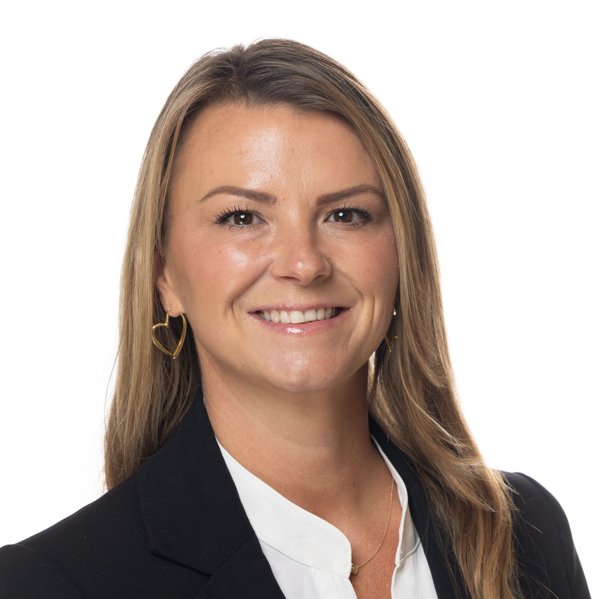 A woman wearing a black jacket and white shirt is smiling for the camera.