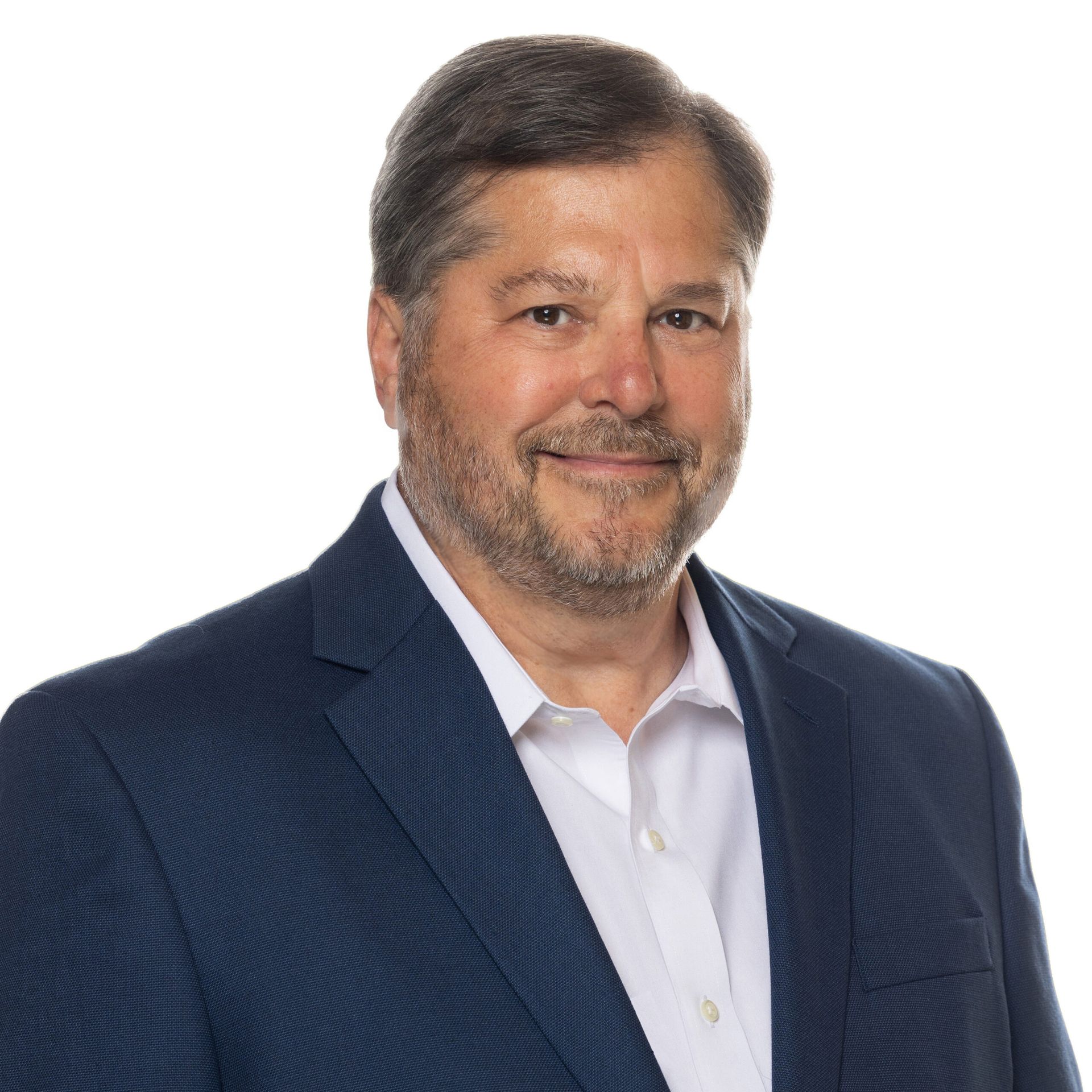 A man with a beard is wearing a blue suit and white shirt.