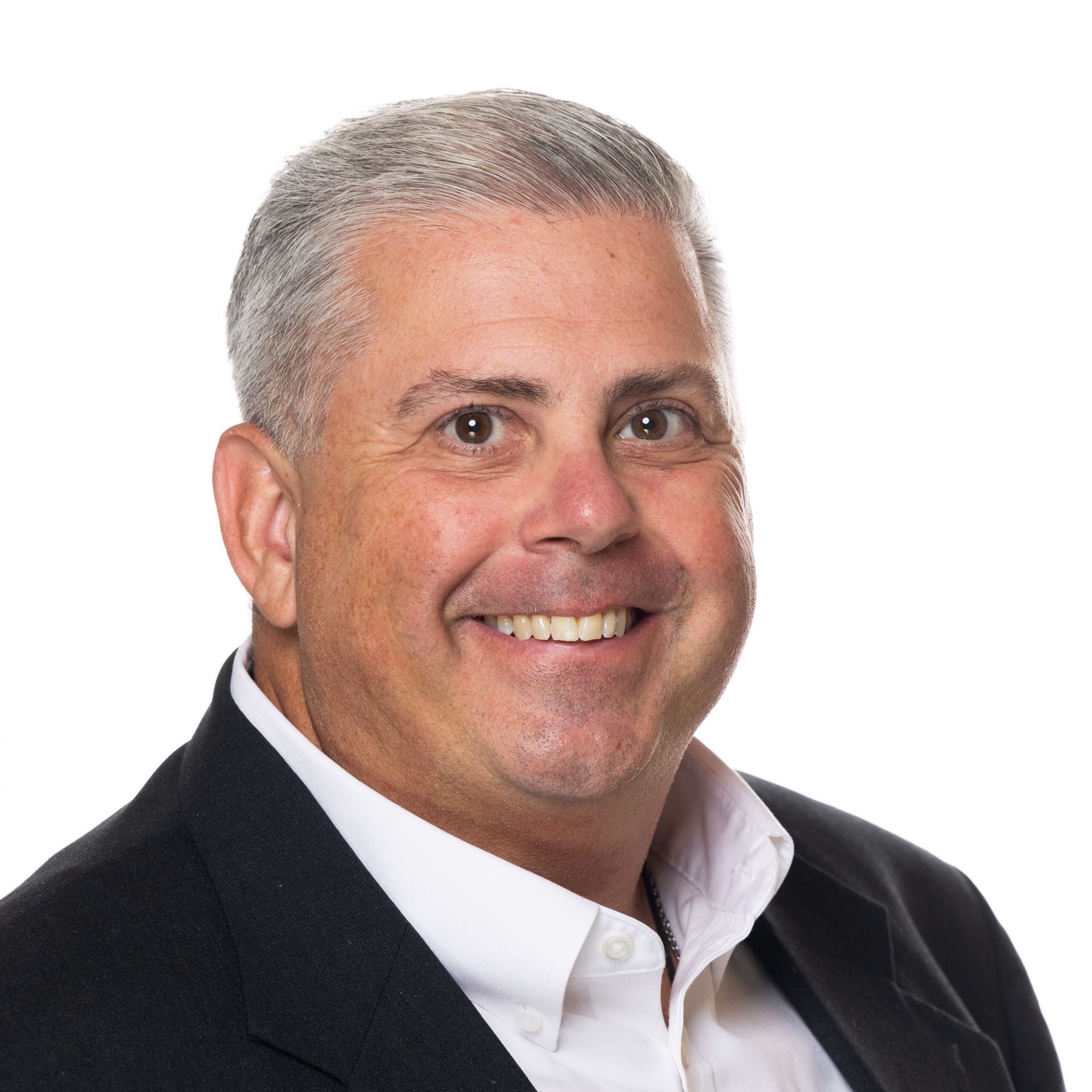 A man in a suit and white shirt is smiling for the camera