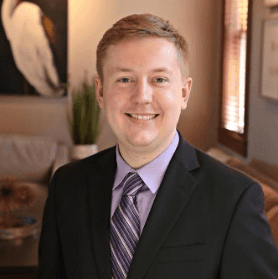A man in a suit and tie is smiling for the camera.