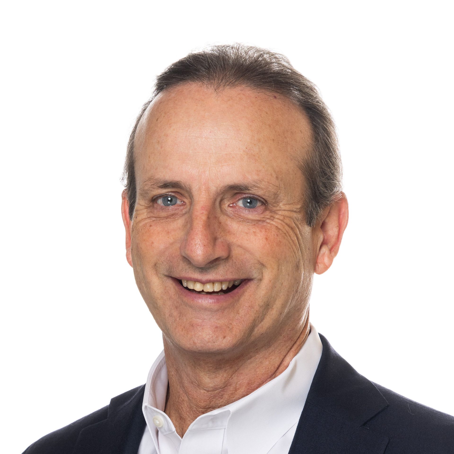A man in a suit and white shirt is smiling for the camera