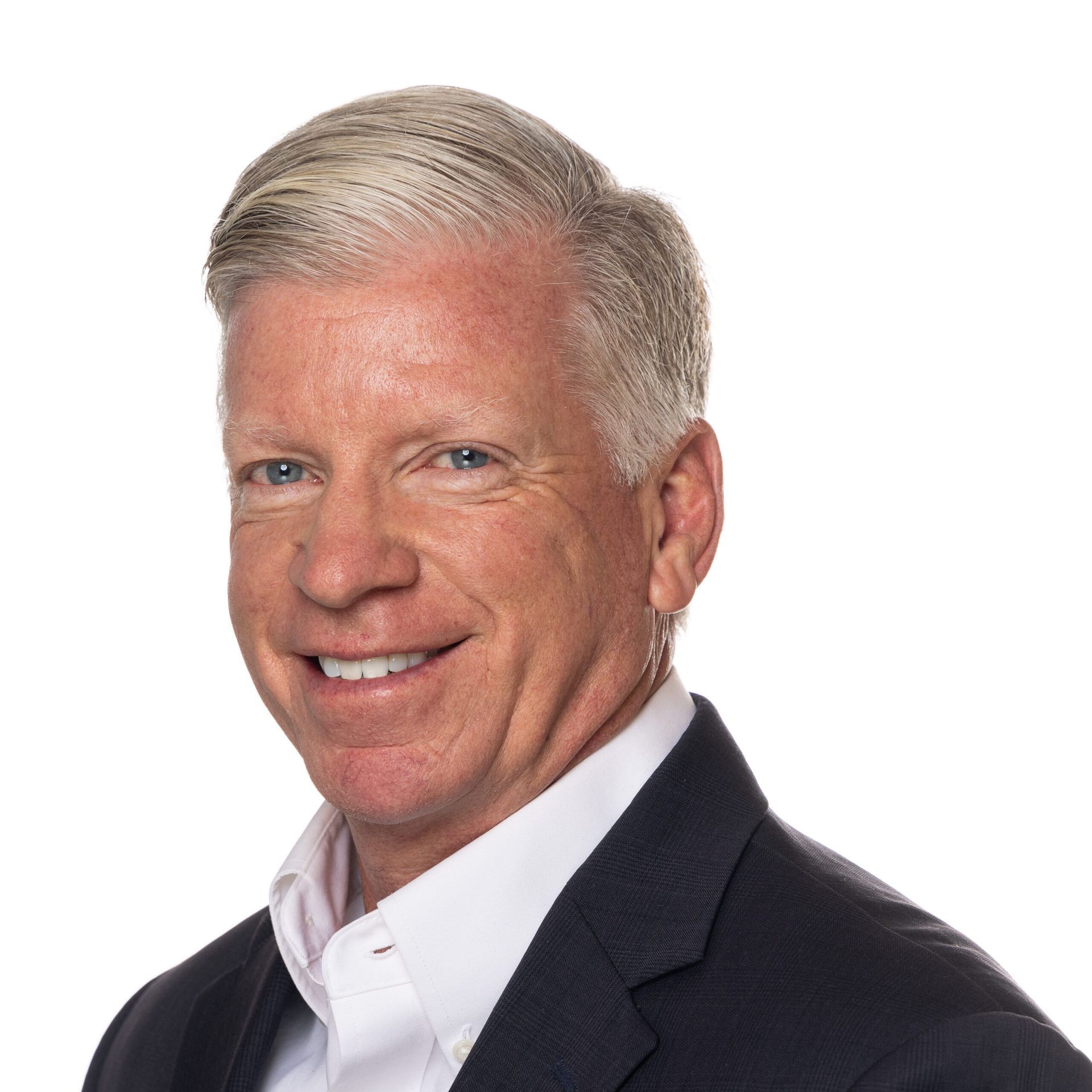A man in a suit and white shirt smiles for the camera