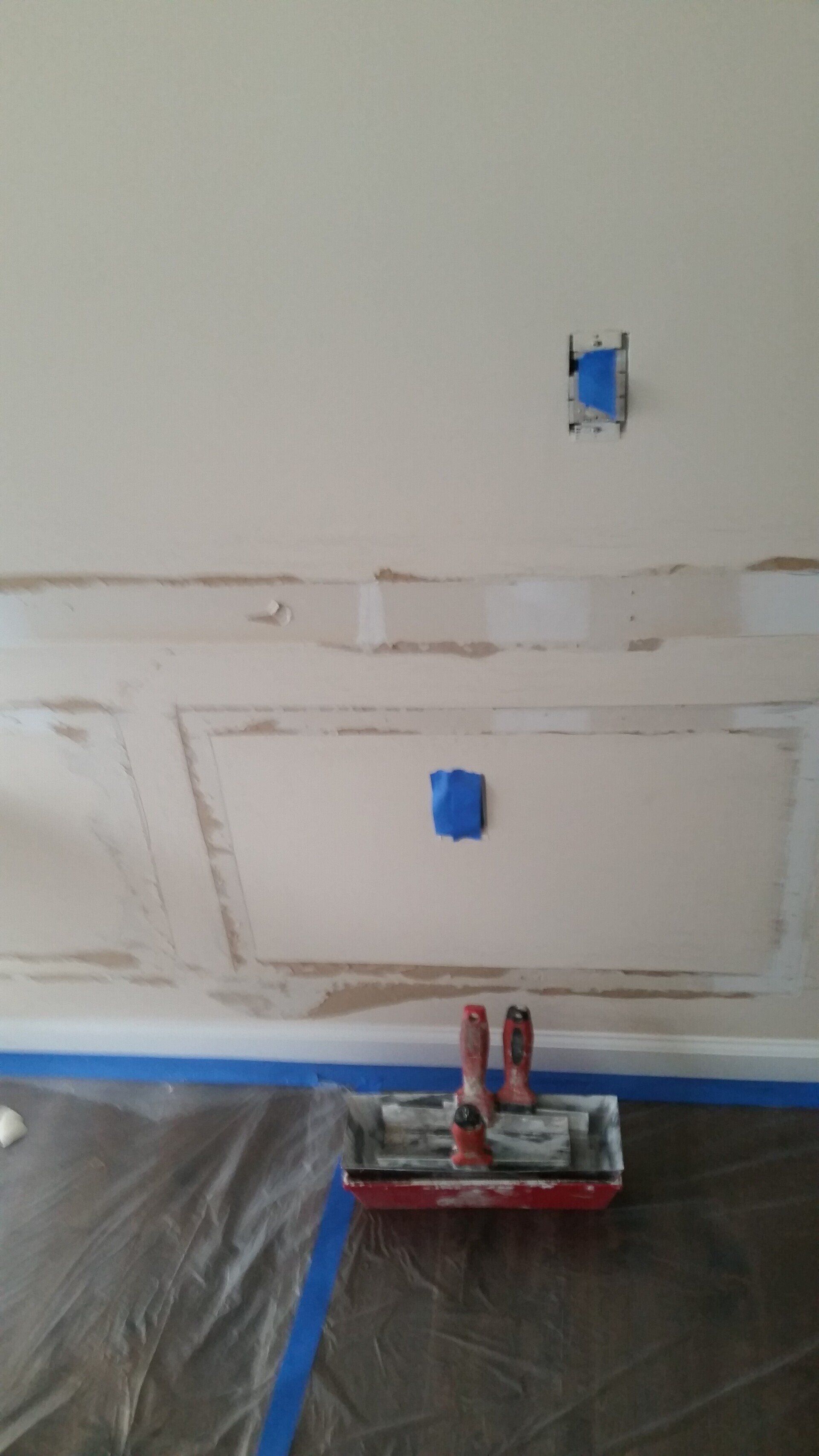 A tray of paint is sitting on the floor in front of a wall.