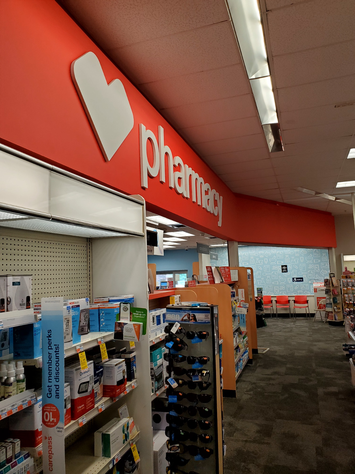 The inside of a pharmacy with a red sign that says pharmacy