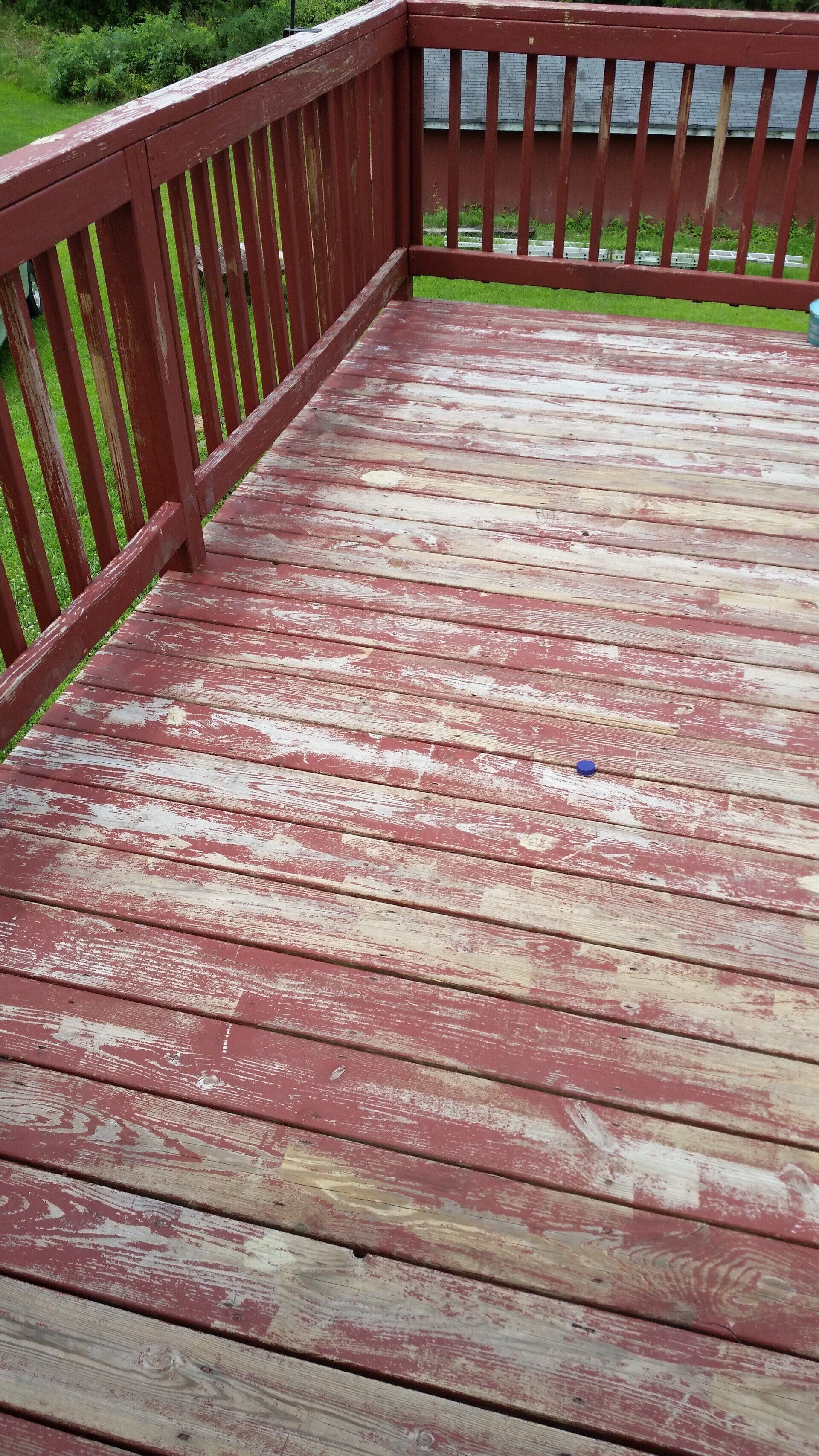 A close up of a wooden deck with a red railing.