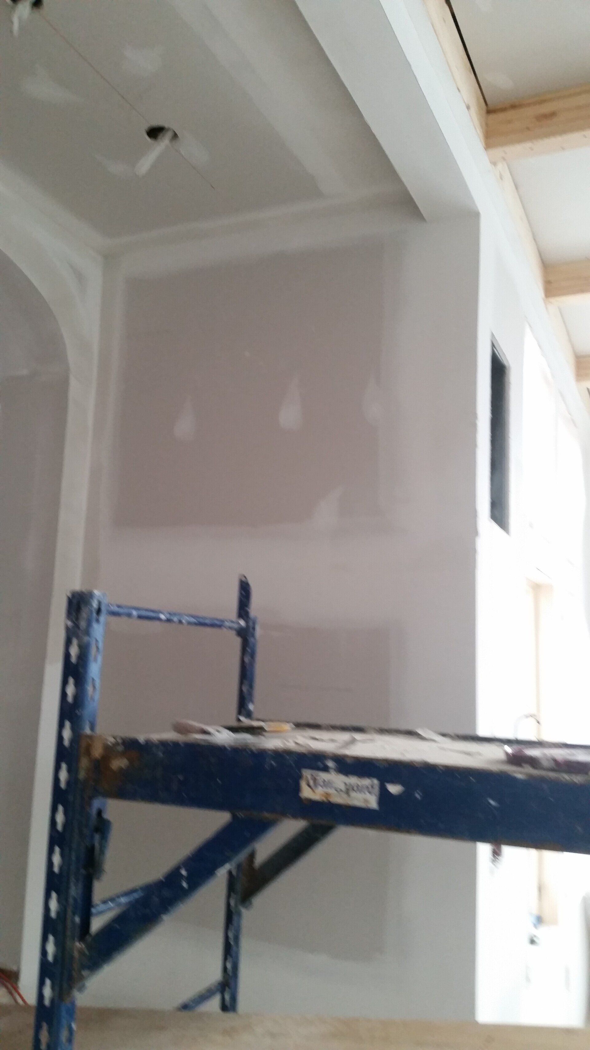 A blue scaffolding is sitting in the middle of a room.