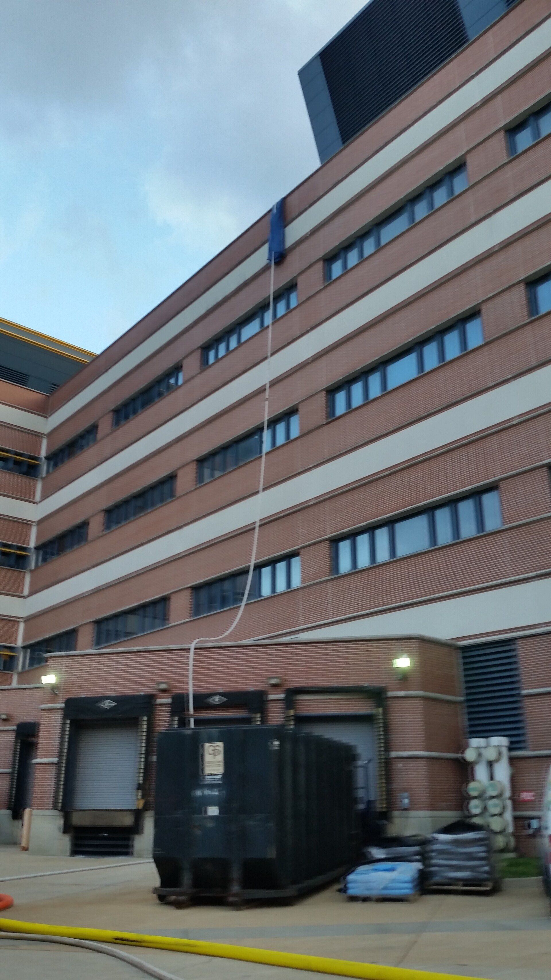 A large brick building with a black dumpster in front of it