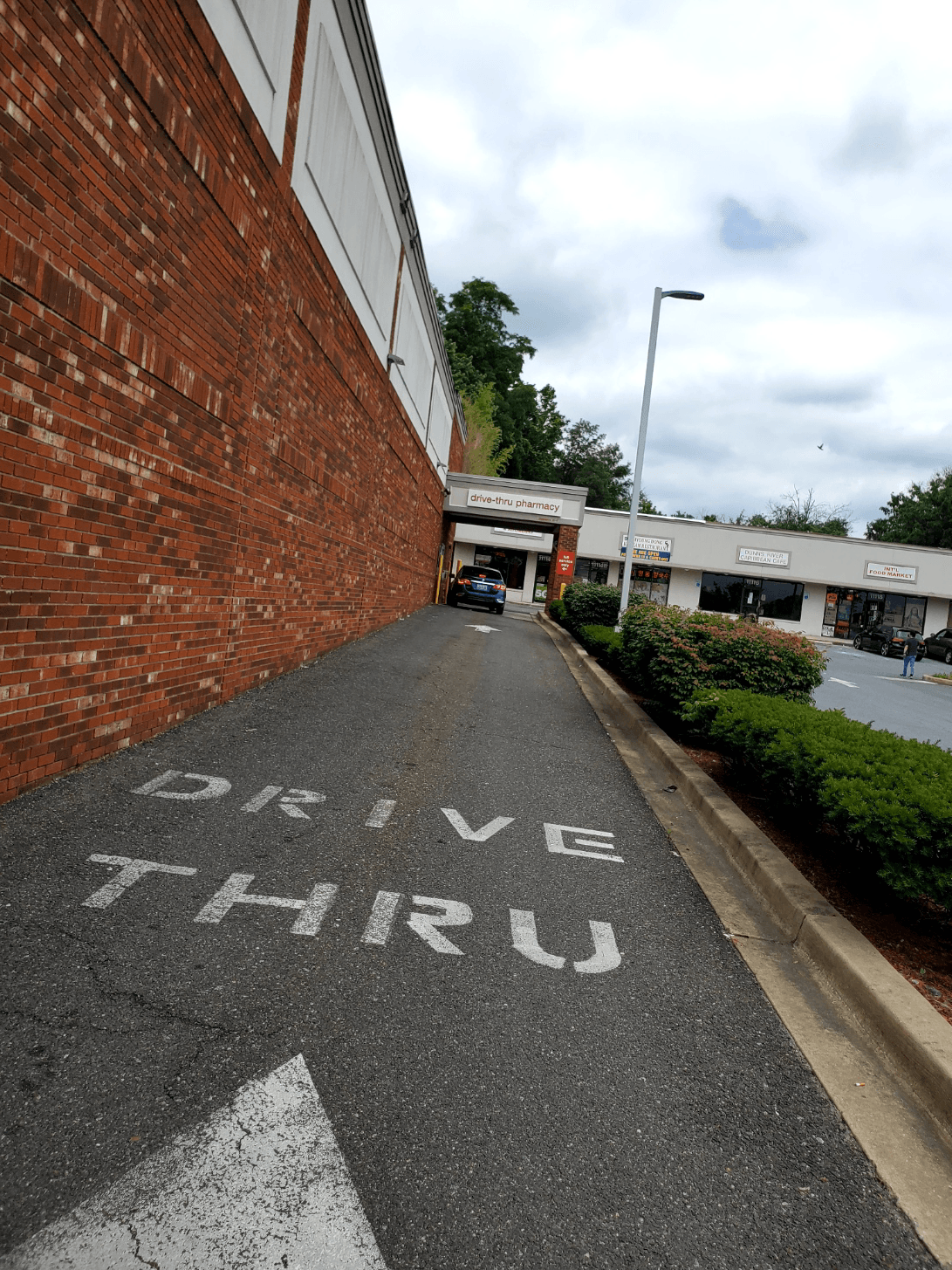 A drive thru sign is painted on the side of a road.