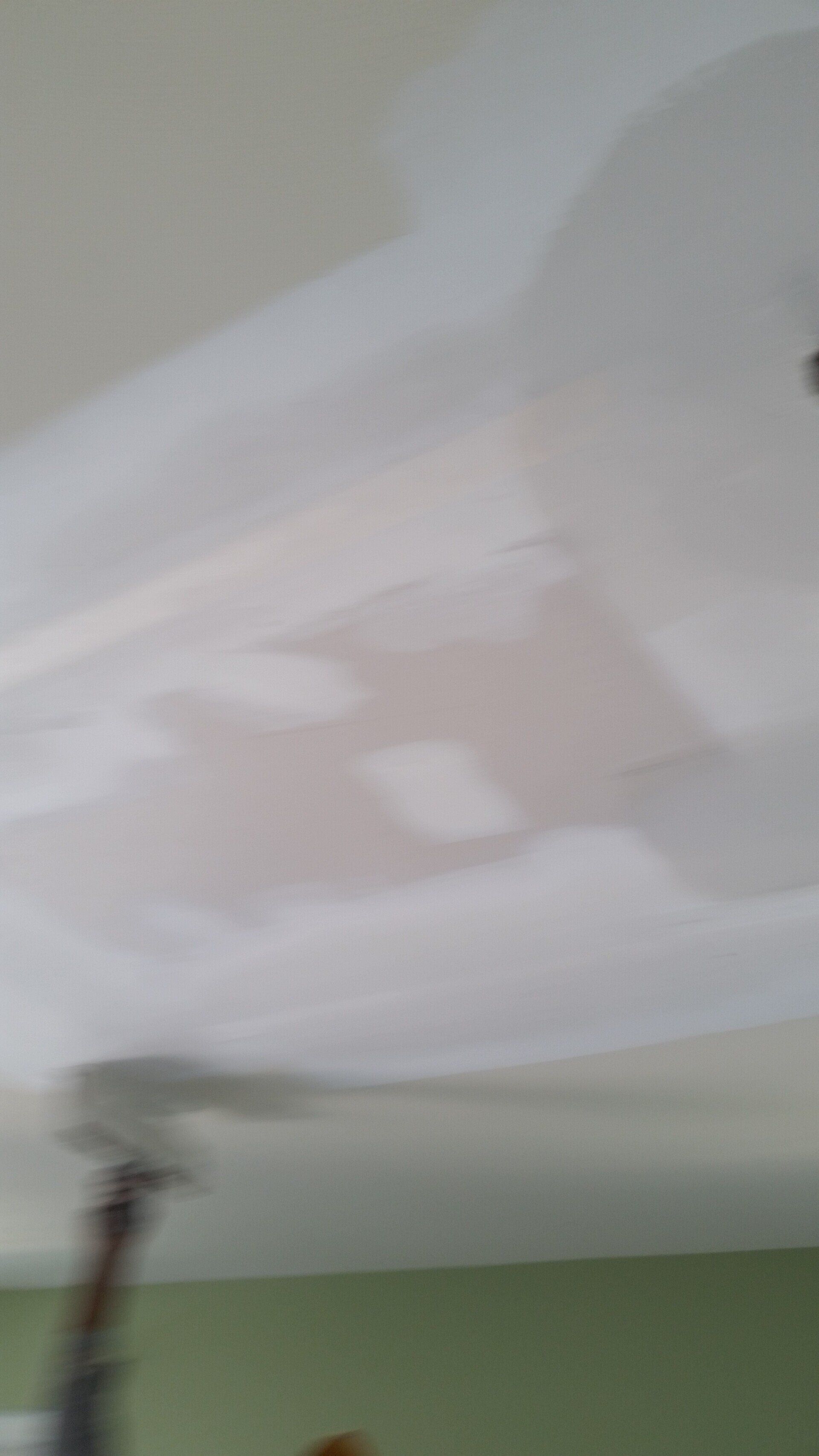 A ceiling fan is hanging from the ceiling of a room.