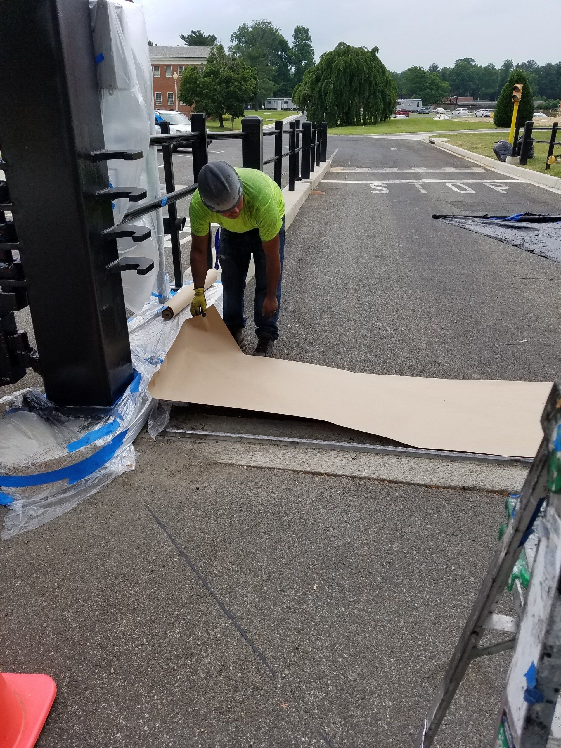 A man is working on a piece of cardboard on the side of the road.