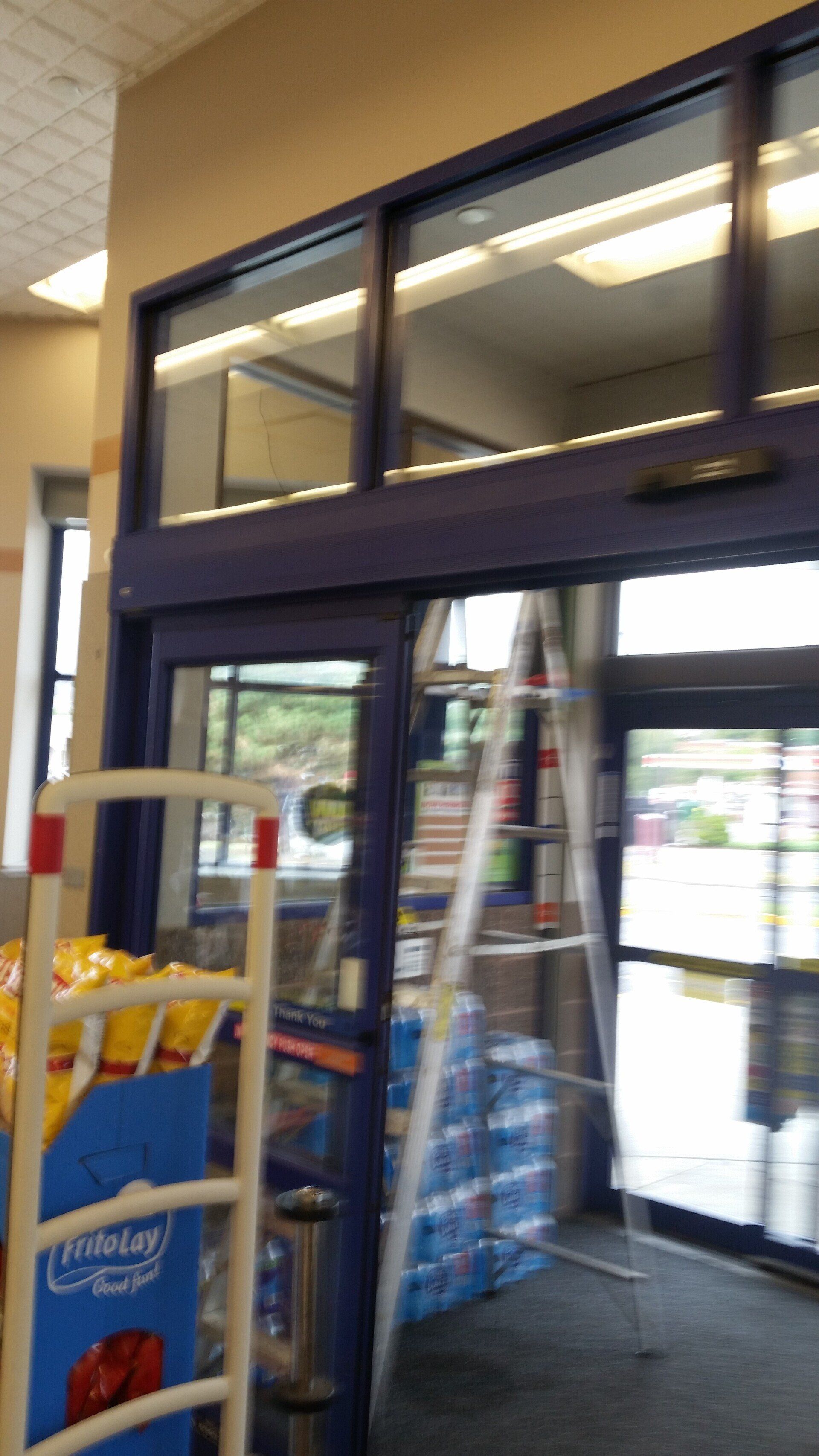 A ladder is sitting in front of a store door.