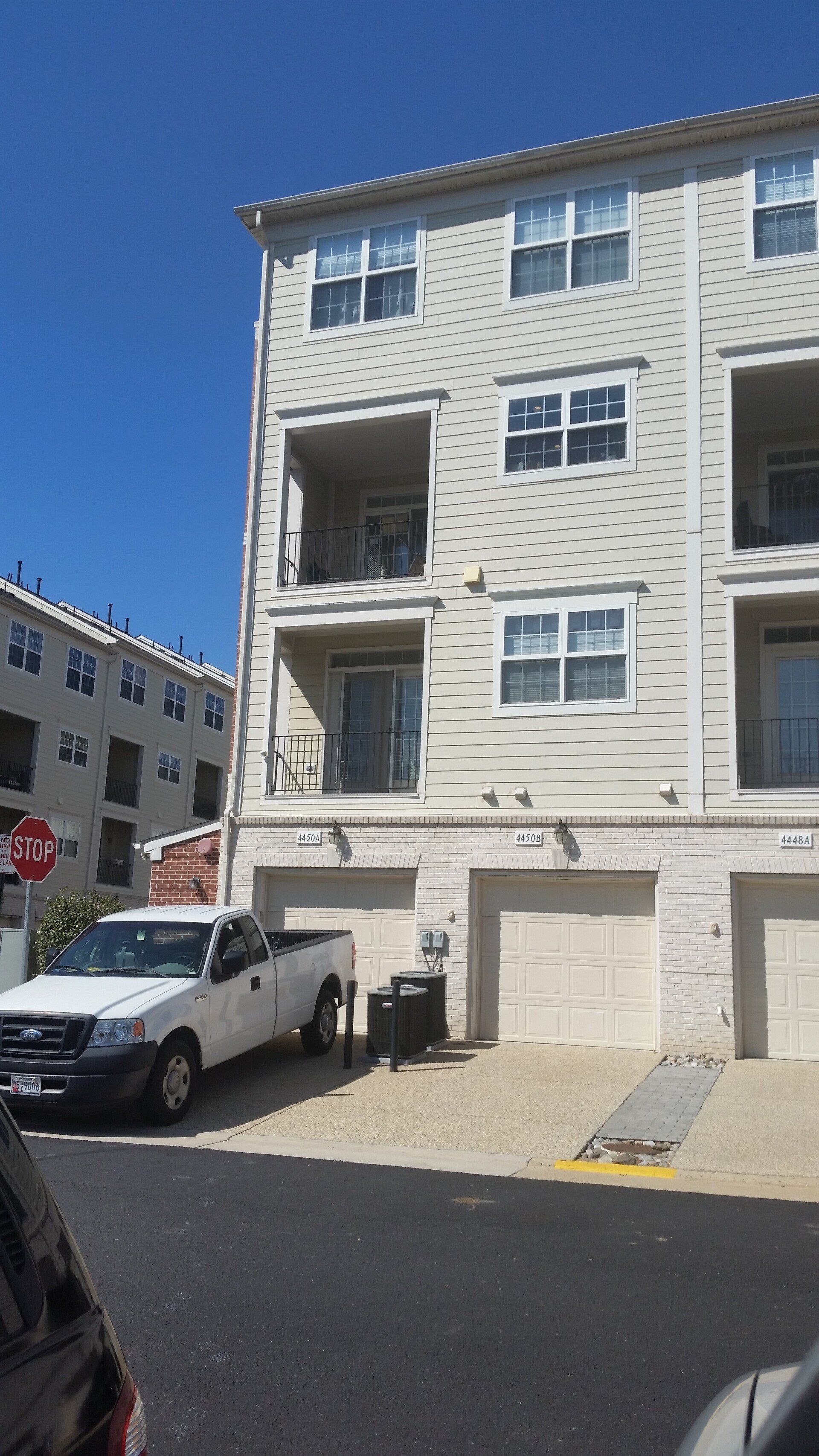 A white truck is parked in front of a building