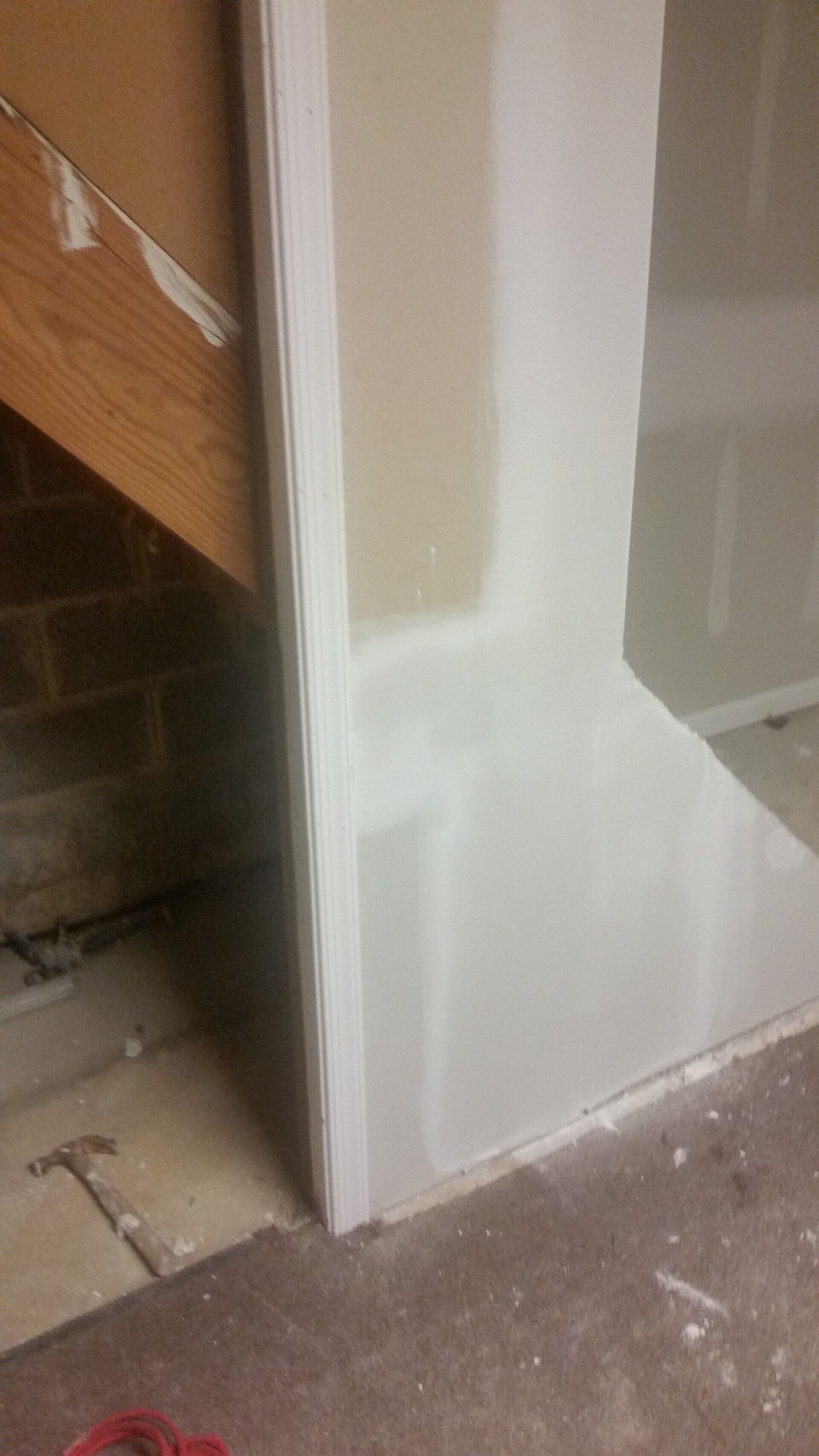 A corner of a wall with a staircase in the background.