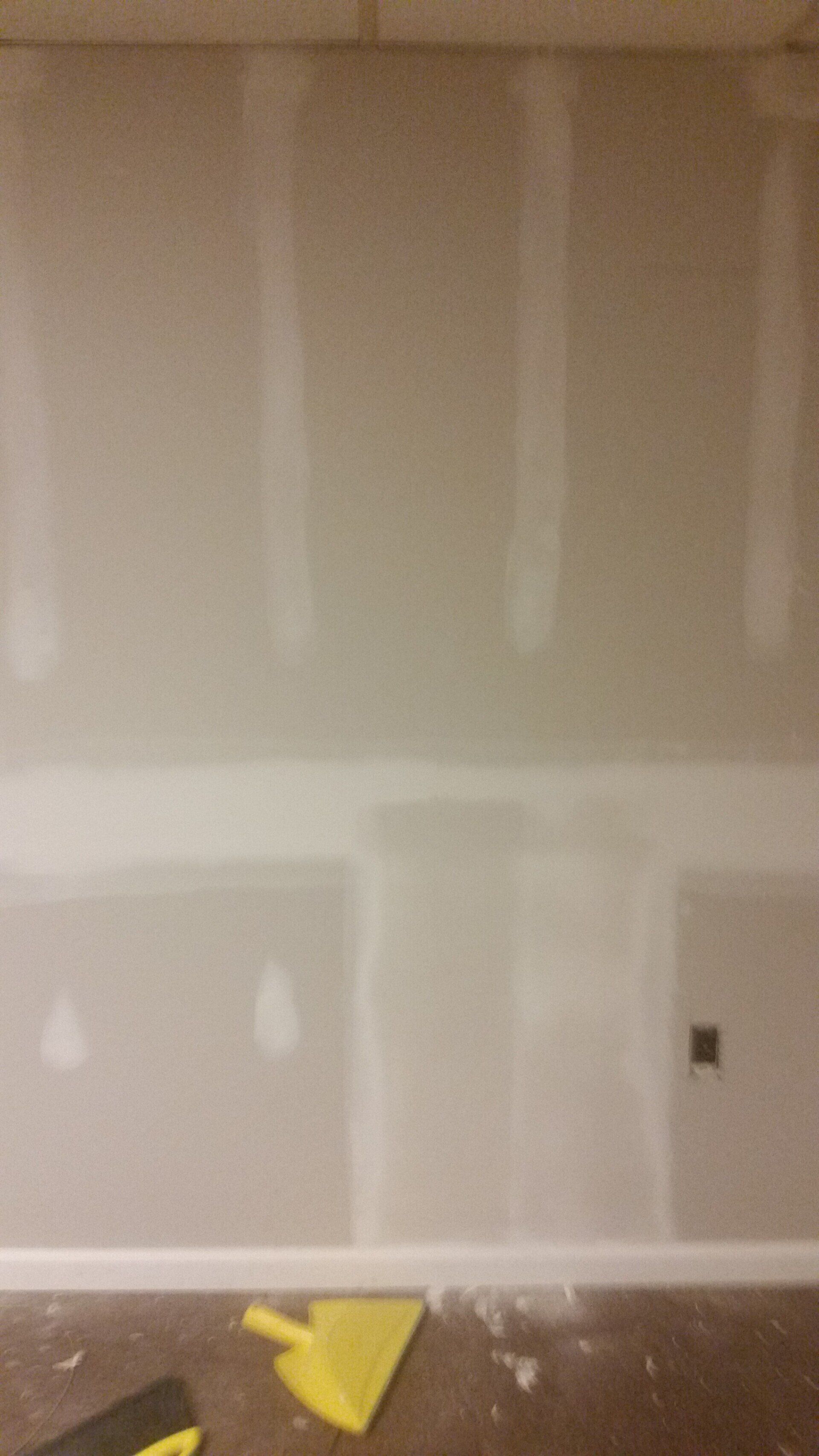 A room with a wall and a broom on the floor.