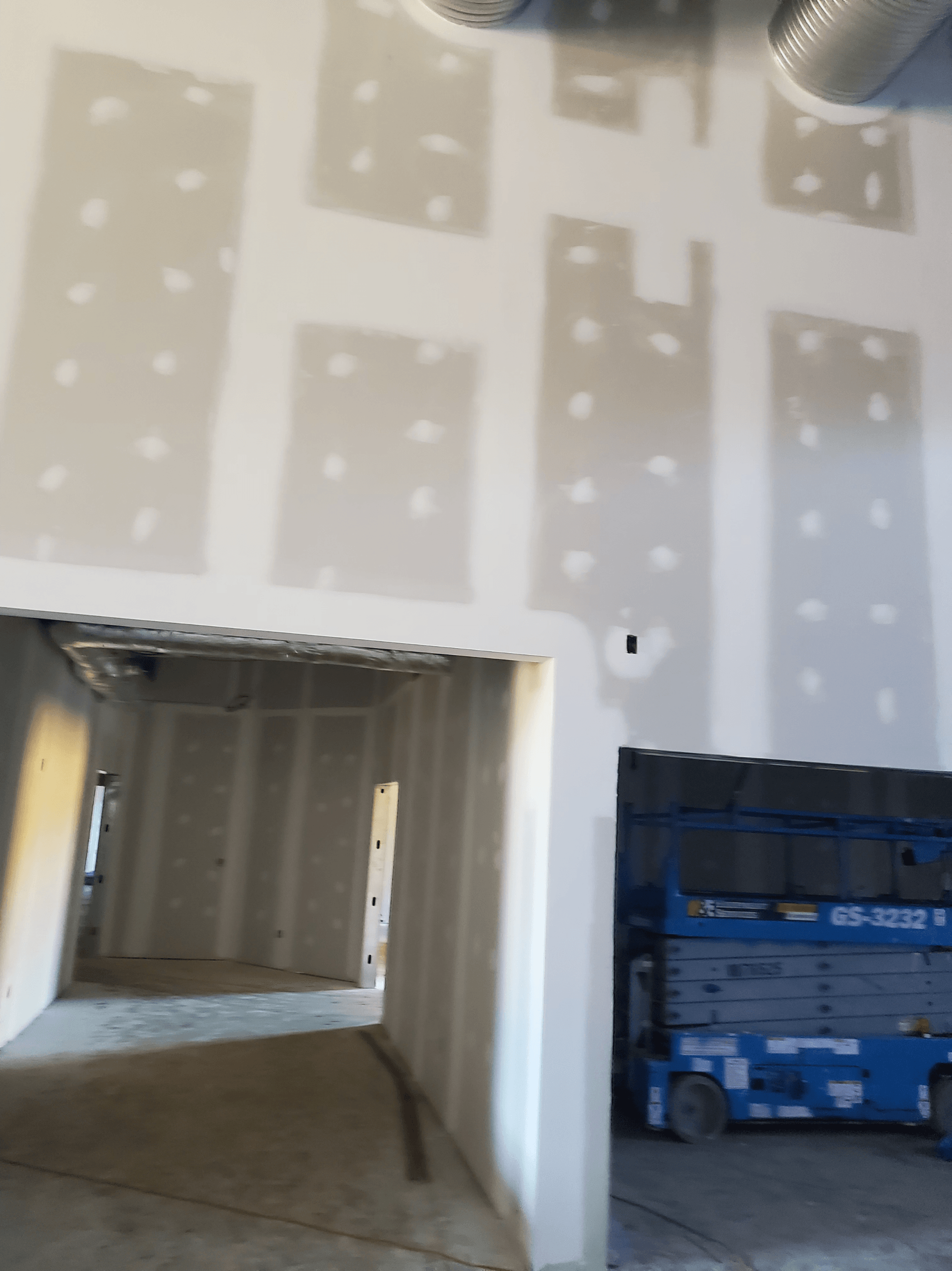 A building under construction with a blue lift in the background