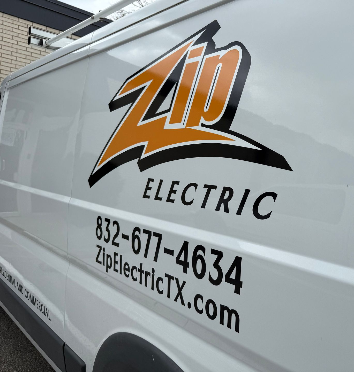 White Zip Electric van with orange and black logo and contact information.