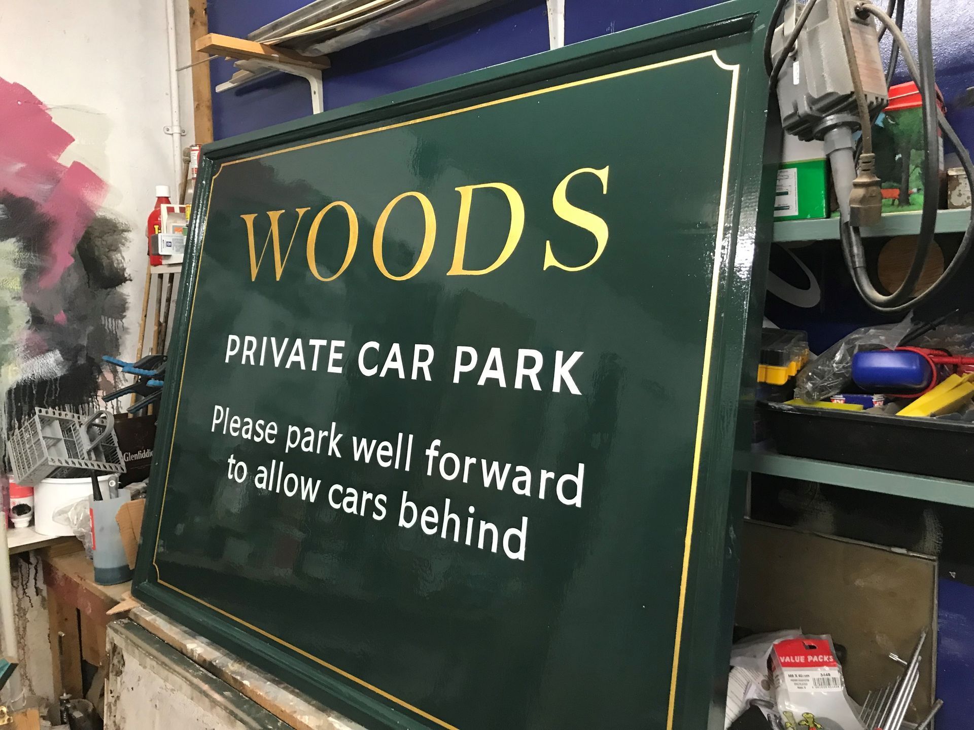 A green sign that says woods private car park