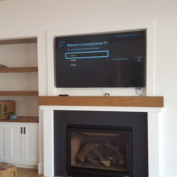 A living room with a fireplace and a flat screen tv.