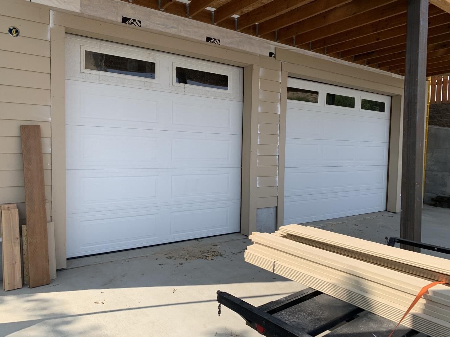 A garage door is being installed in a house under construction.
