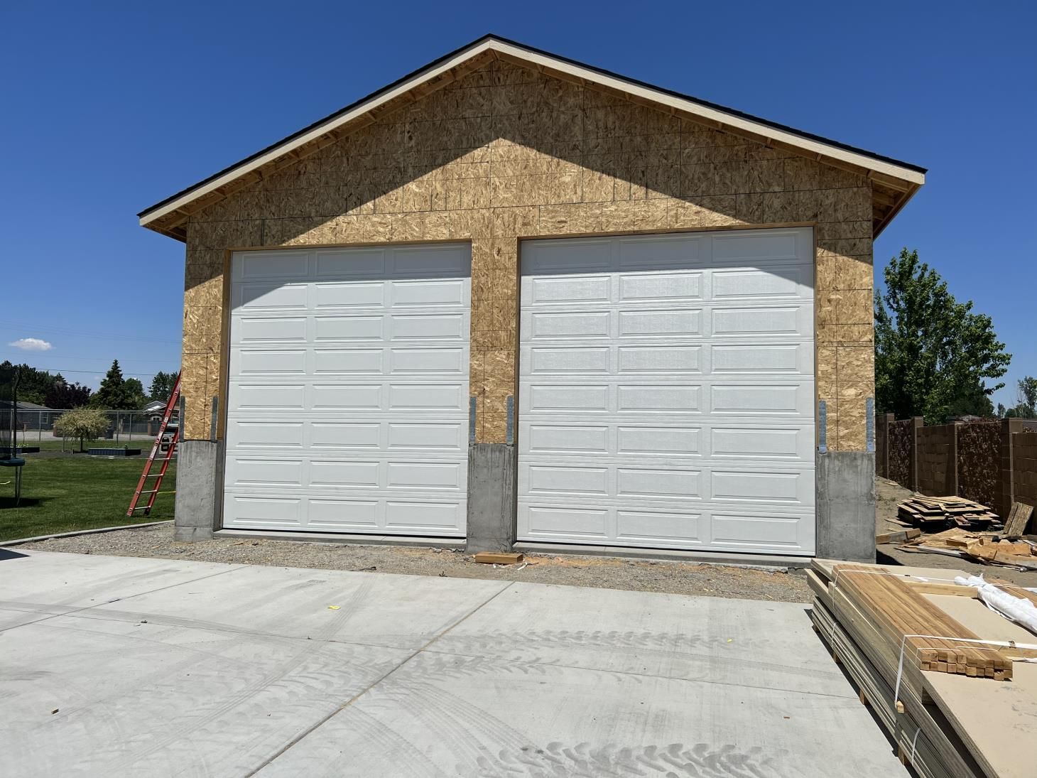 A garage with two white garage doors is being built.