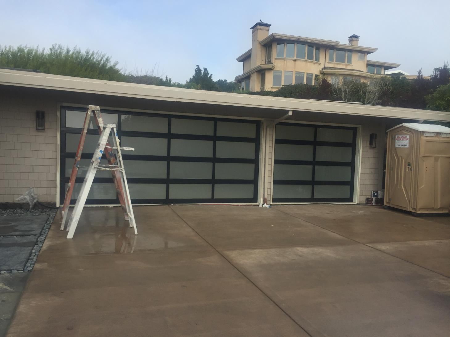 A ladder is sitting in front of a garage door.