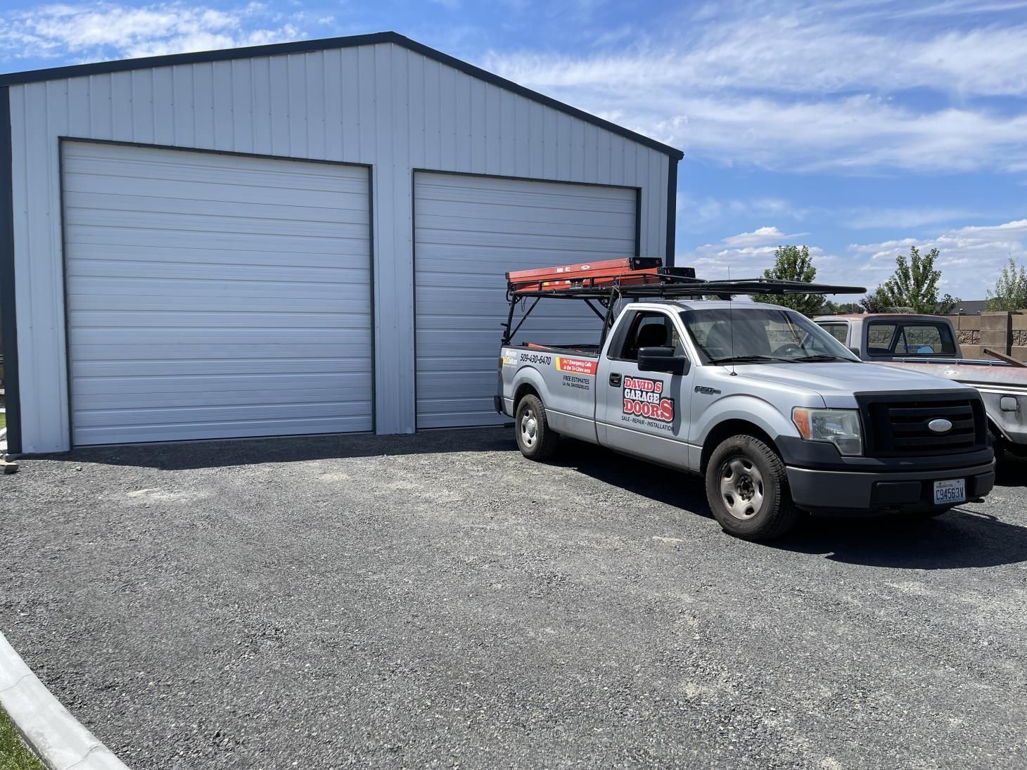 A truck is parked in front of a garage door.