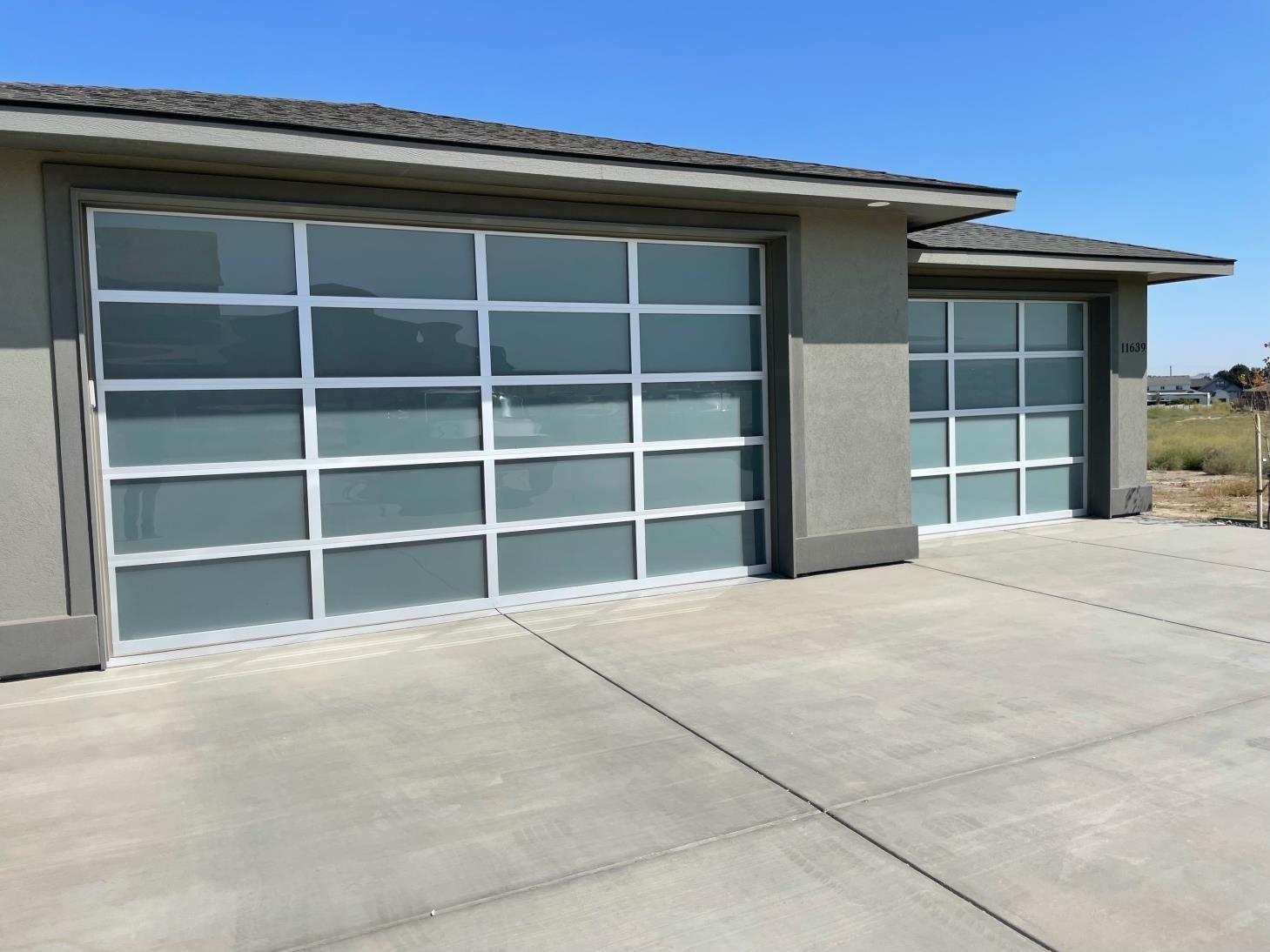 A garage with a lot of windows and a concrete driveway