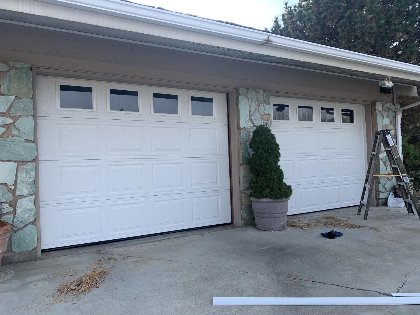 A white garage door is being installed on a house.