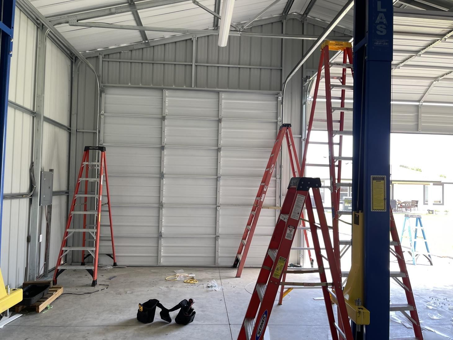 A garage with a ladder in the middle of it