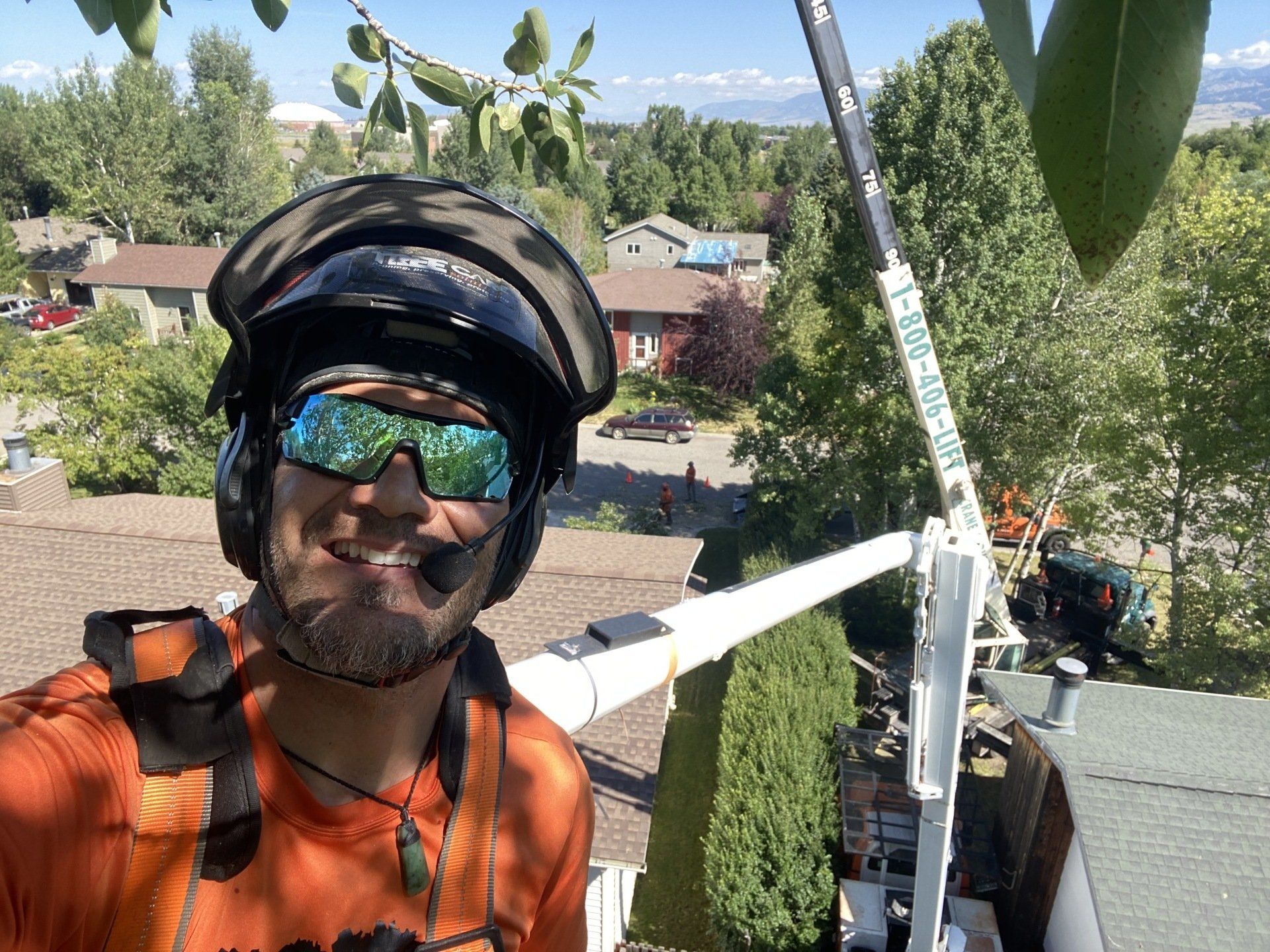A man wearing a helmet and sunglasses is standing on a roof.