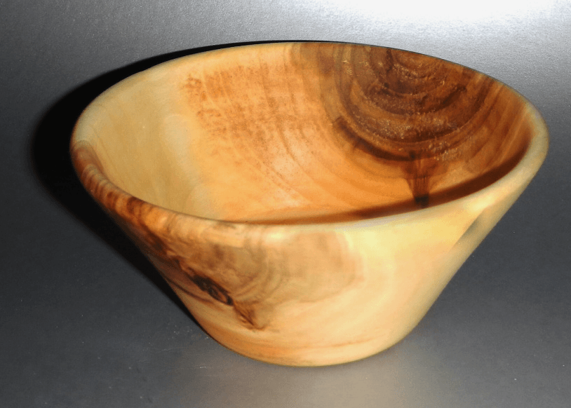 A small wooden bowl is sitting on a table