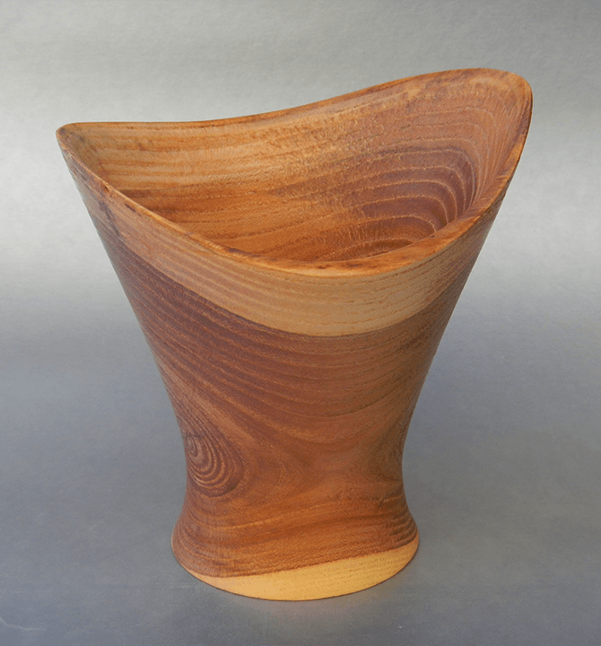 A wooden bowl is sitting on a gray surface