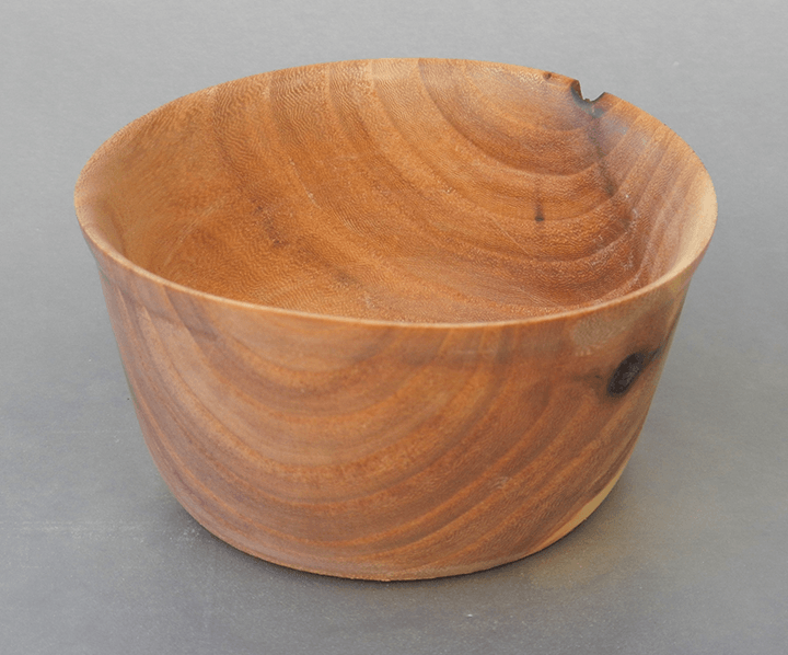A small wooden bowl is sitting on a table