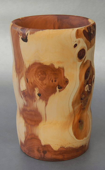 A close up of a wooden cup on a table.