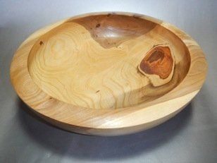 A large wooden bowl is sitting on a table.