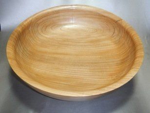 A large wooden bowl is sitting on a table.