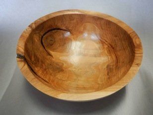 A wooden bowl is sitting on a table.