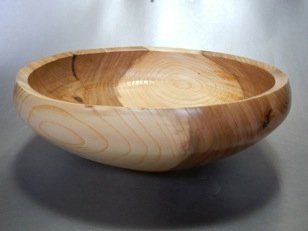 A wooden bowl is sitting on a table.