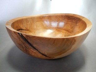 A large wooden bowl is sitting on a table.