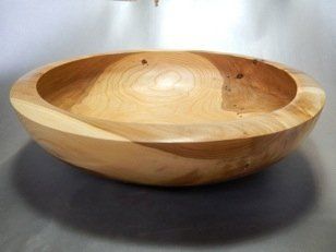 A wooden bowl is sitting on a table.