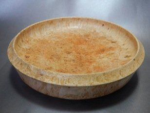 A wooden bowl is sitting on a table.