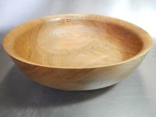 A wooden bowl is sitting on a table.